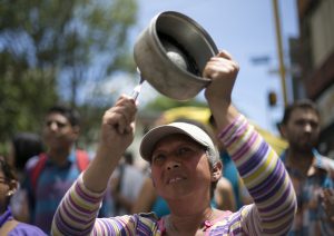 A woman bangs a pot to protest Venezuela's President Nicolas Maduro in Los Teques on the outskirts of Caracas, Venezuela, Wednesday, Sept. 7, 2016. Venezuelans are marching in cities across the country to demand authorities allow a recall referendum against Maduro to go forward this year. (AP Photo/Ariana Cubillos) Venezuela Opposition Protest