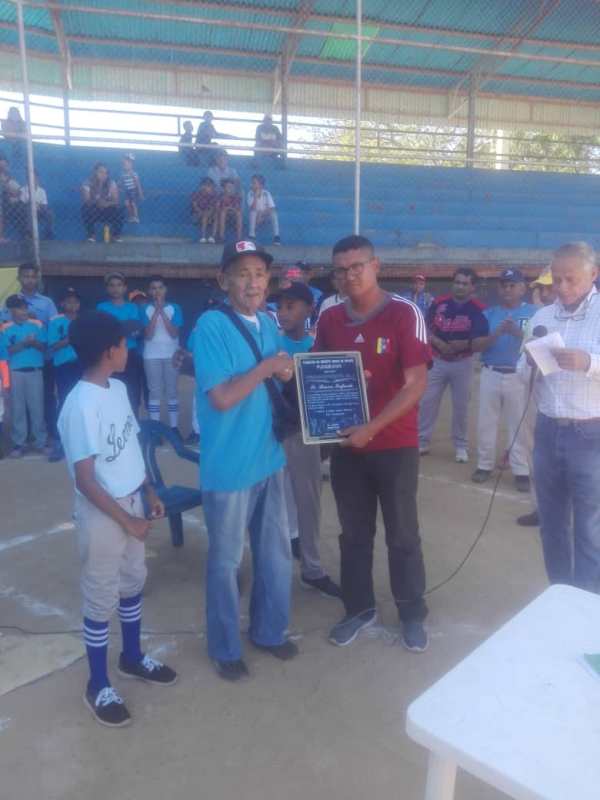 El legendario ex-lanzador y dirigente regional de Criollitos de Venezuela, Simón Infante, recibió placxa alegórica al homenaje.jpg