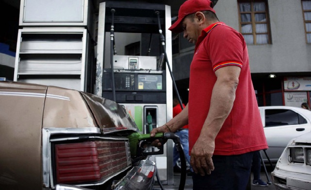 Trabajador de bomba de gasolina surtiendo combustible en gasolinera de PDVSA